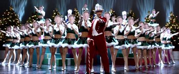 Movie still from “A Very Harold & Kumar Christmas” (2011), directed by Todd Strauss-Schulson – A group of people in costumes on a stage; Wide shot, Over the shoulder angle