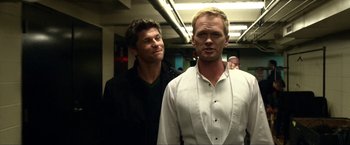 Movie still from “A Very Harold & Kumar Christmas” (2011), directed by Todd Strauss-Schulson – Two men standing next to each other in a room; Medium shot, Over the shoulder angle