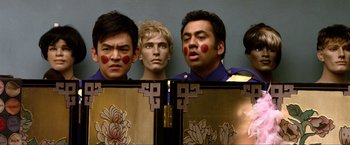 Movie still from “A Very Harold & Kumar Christmas” (2011), directed by Todd Strauss-Schulson – A group of men standing next to each other in front of a cabinet; Close Up shot, Over the shoulder angle