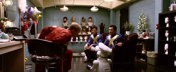 Movie still from “A Very Harold & Kumar Christmas” (2011), directed by Todd Strauss-Schulson – A group of people sitting around a room with a robot; Wide shot, Over the shoulder angle