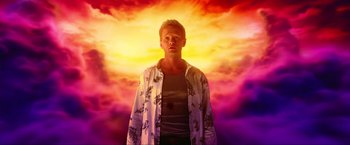 Movie still from “A Very Harold & Kumar Christmas” (2011), directed by Todd Strauss-Schulson – A man standing in front of a colorful background; Medium shot, Low angle