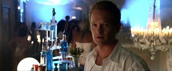 Movie still from “A Very Harold & Kumar Christmas” (2011), directed by Todd Strauss-Schulson – A person in a room near a table; Close Up shot, Over the shoulder angle