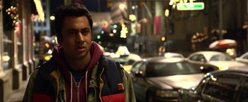 Movie still from “A Very Harold & Kumar Christmas” (2011), directed by Todd Strauss-Schulson – A man standing on a street with cars behind him; Close Up shot, Over the shoulder angle