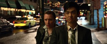 Movie still from “A Very Harold & Kumar Christmas” (2011), directed by Todd Strauss-Schulson – A couple of men standing next to each other on a street; Close Up shot, Over the shoulder angle