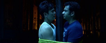 Movie still from “A Very Harold & Kumar Christmas” (2011), directed by Todd Strauss-Schulson – Two young men facing each other with a rope around their neck; Medium shot, Overhead angle