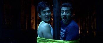 Movie still from “A Very Harold & Kumar Christmas” (2011), directed by Todd Strauss-Schulson – Two young men posing for a picture while hanging from a rope; Medium shot, Low angle