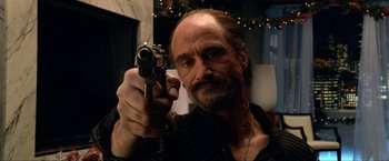 Movie still from “A Very Harold & Kumar Christmas” (2011), directed by Todd Strauss-Schulson – A man holding a gun in his right hand; Close Up shot, Over the shoulder angle