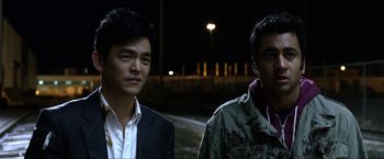 Movie still from “A Very Harold & Kumar Christmas” (2011), directed by Todd Strauss-Schulson – Two men standing next to each other on a street at night; Close Up shot, Over the shoulder angle