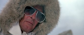 Movie still from “A View to a Kill” (1985), directed by John Glen – A man wearing a furry hat and sunglasses; Close Up shot, Low angle