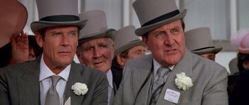 Movie still from “A View to a Kill” (1985), directed by John Glen – A group of men in top hats and suits; Close Up shot, Low angle