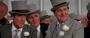 Movie still from “A View to a Kill” (1985), directed by John Glen – A group of men in top hats and ties; Close Up shot, Low angle