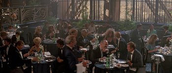 Movie still from “A View to a Kill” (1985), directed by John Glen – A group of people sitting at tables eating food; Wide shot, High angle