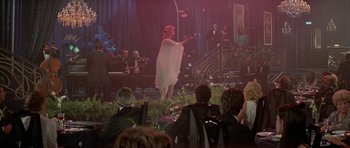 Movie still from “A View to a Kill” (1985), directed by John Glen – A woman in a white dress performing on a stage; Wide shot, Over the shoulder angle