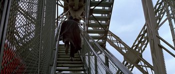 Movie still from “A View to a Kill” (1985), directed by John Glen – A man walking up a set of metal stairs; Wide shot, Low angle