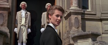 A woman in a black suit standing in front of a building