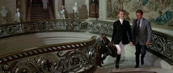 Movie still from “A View to a Kill” (1985), directed by John Glen – A man riding a horse next to a statue; Wide shot, Low angle
