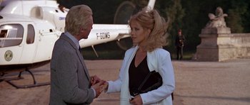 Movie still from “A View to a Kill” (1985), directed by John Glen – A man and a woman shaking hands in front of an airplane; Medium shot, Over the shoulder angle