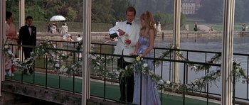 Movie still from “A View to a Kill” (1985), directed by John Glen – A man and a woman standing next to a railing; Medium shot, High angle