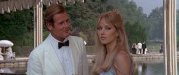 Movie still from “A View to a Kill” (1985), directed by John Glen – A man and a woman standing next to each other; Close Up shot, Over the shoulder angle