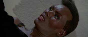 Movie still from “A View to a Kill” (1985), directed by John Glen – A woman's face with a smile; Close Up shot, Overhead angle