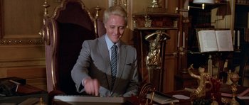 Movie still from “A View to a Kill” (1985), directed by John Glen – A man in a gray suit and a blue striped neck tie; Medium shot, Low angle