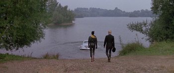 Movie still from “A View to a Kill” (1985), directed by John Glen – A man and a woman in wetsuits walking away from a boat; Wide shot, High angle