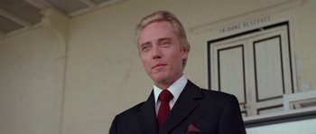 Movie still from “A View to a Kill” (1985), directed by John Glen – A person wearing a suit and tie; Close Up shot, Low angle