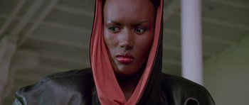 Movie still from “A View to a Kill” (1985), directed by John Glen – A person wearing a black and pink scarf; Close Up shot, Low angle