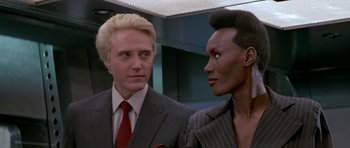 Movie still from “A View to a Kill” (1985), directed by John Glen – A man and a woman standing next to each other; Close Up shot, Low angle