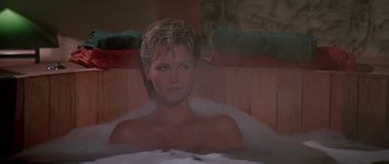 Movie still from “A View to a Kill” (1985), directed by John Glen – A woman sitting in a bath tub in a room; Close Up shot, High angle
