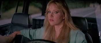 Movie still from “A View to a Kill” (1985), directed by John Glen – A woman sitting in the driver's seat of a car; Close Up shot, Over the shoulder angle