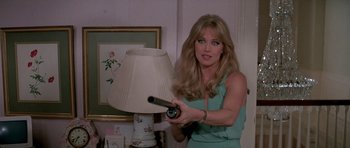 Movie still from “A View to a Kill” (1985), directed by John Glen – A woman holding a video game controller in her hand; Medium shot, Over the shoulder angle