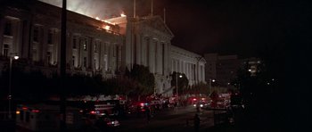 Movie still from “A View to a Kill” (1985), directed by John Glen – A large building that has a fire in it; Extreme Wide shot, Low angle