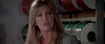 Movie still from “A View to a Kill” (1985), directed by John Glen – A person with long hair and blue eyes; Close Up shot, Over the shoulder angle