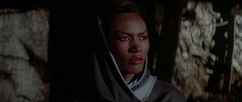 Movie still from “A View to a Kill” (1985), directed by John Glen – A woman in a nun's outfit is looking at the camera; Close Up shot, Over the shoulder angle