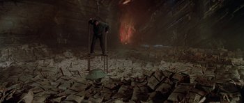 Movie still from “A View to a Kill” (1985), directed by John Glen – A man standing on top of a pile of papers; Wide shot, High angle