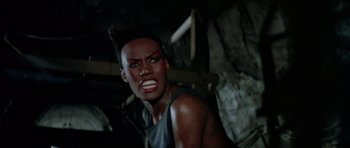 Movie still from “A View to a Kill” (1985), directed by John Glen – A woman with red makeup on her face; Close Up shot, Low angle