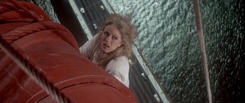 Movie still from “A View to a Kill” (1985), directed by John Glen – A woman leaning on the side of a building; Medium shot, Overhead angle