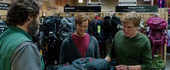 Movie still from “A Walk in the Woods” (2015), directed by Ken Kwapis – A woman standing in front of a bunch of backpacks; Medium shot, Over the shoulder angle