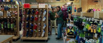 Movie still from “A Walk in the Woods” (2015), directed by Ken Kwapis – Two men standing next to each other in a store; Medium shot, Over the shoulder angle