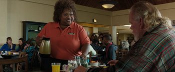 Movie still from “A Walk in the Woods” (2015), directed by Ken Kwapis – A woman in an orange shirt is serving food; Medium shot, Over the shoulder angle