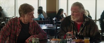 Movie still from “A Walk in the Woods” (2015), directed by Ken Kwapis – Two men sitting at a table in a restaurant; Medium shot, Low angle