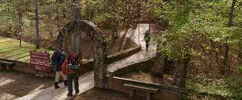 Movie still from “A Walk in the Woods” (2015), directed by Ken Kwapis – A man riding a bike down a stone path through the woods; Extreme Wide shot, High angle