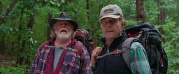 Movie still from “A Walk in the Woods” (2015), directed by Ken Kwapis – Two men with backpacks and hats in the woods; Medium shot, Over the shoulder angle