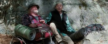 Movie still from “A Walk in the Woods” (2015), directed by Ken Kwapis – Two men sitting on a bench in the woods; Medium shot, Low angle