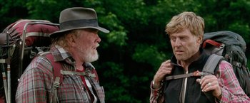 Movie still from “A Walk in the Woods” (2015), directed by Ken Kwapis – A man and a woman standing next to each other in the woods; Medium shot, Over the shoulder angle