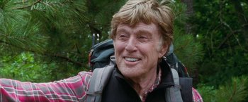 Movie still from “A Walk in the Woods” (2015), directed by Ken Kwapis – An older man wearing a backpack smiling for the camera; Close Up shot, Low angle