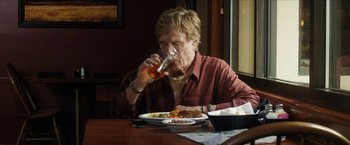Movie still from “A Walk in the Woods” (2015), directed by Ken Kwapis – A man sitting at a dinner table drinking a beer; Medium shot, Low angle