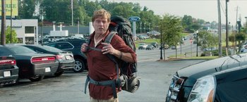 Movie still from “A Walk in the Woods” (2015), directed by Ken Kwapis – A man with a large backpack walking down a street; Medium shot, Over the shoulder angle