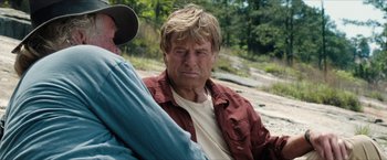 Movie still from “A Walk in the Woods” (2015), directed by Ken Kwapis – An older man sitting next to another man on the ground; Close Up shot, Over the shoulder angle